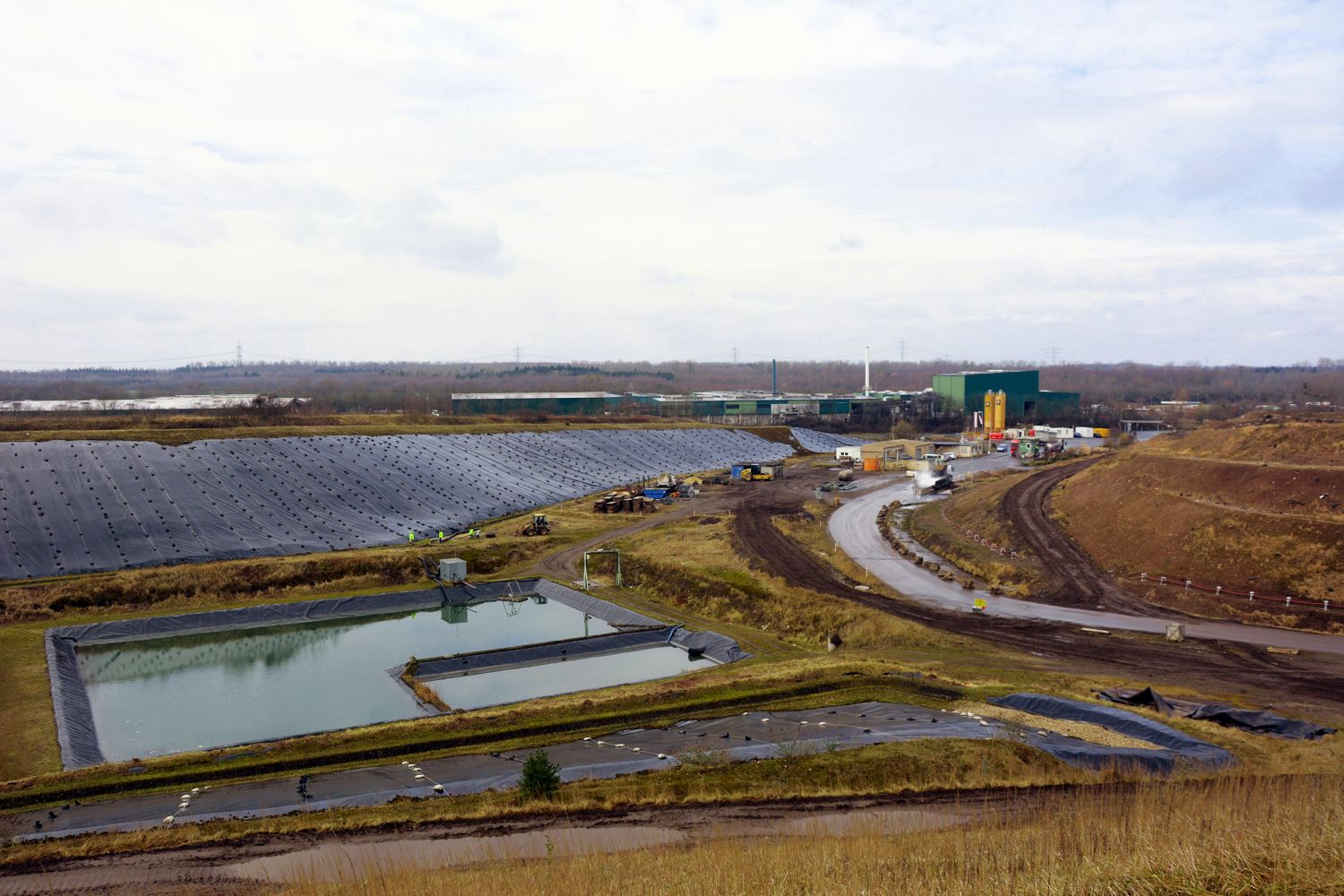 Temporäre Oberflächenabdichtung auf der SAD - mit den Folien werden die Staubverwehungen vermieden und das Eindringen von Regenwasser in den Deponiekörper verhindert. Das aufgefangene Wasser kann abgeleitet werden.